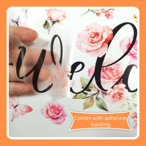 Detail showing hand peeling self-adhesive floral Welcome wall sticker from transparent backing