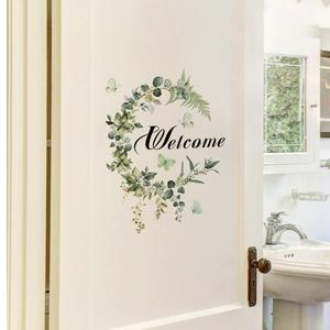 Detail of floral Welcome wreath sticker with butterflies on a white wooden door