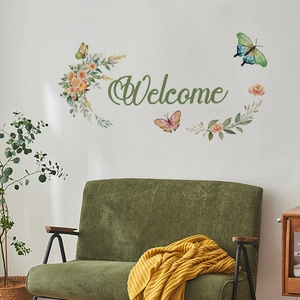 Detailed view of Welcome wall decal with watercolor flowers and butterflies on a white wall