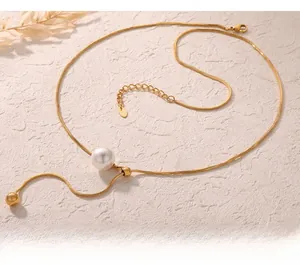 Détail du collier chaîne serpent dorée avec perle blanche et pendentif goutte perlé