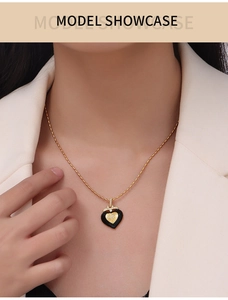 Mannequin portant collier doré avec pendentif cœur émail noir et cristal étincelant