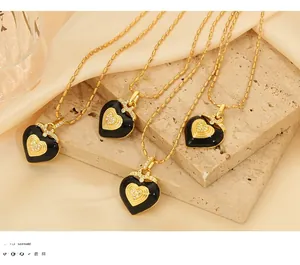 Vue détaillée de pendentifs cœur en émail avec chaînes à billes dorées sur de la soie