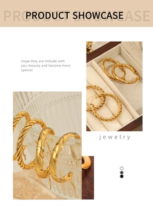 Detail of gold twisted hoop earrings showing intricate woven and flat spiral textures