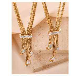 Macro shot of gold-plated tassel necklace with shimmering crystal-paved U-shaped detail