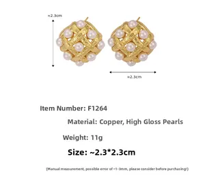 Macro view of woven textured gold earrings with inlaid white shell pearl and dimensions