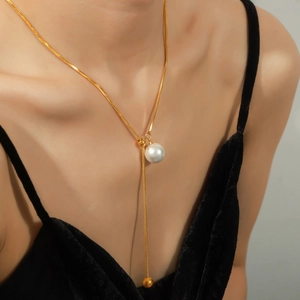 Élégant collier en Y plaqué or avec pendentif perle blanche et glands à billes dorées
