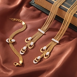 Elegant gold multi-strand chain jewelry set with diamond-encrusted buckle on silk background