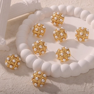 Vintage woven gold square earrings with inlaid pearls shown on a decorative tray