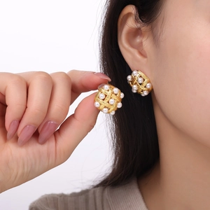 Vintage woven gold plated earrings with high-luster pearls worn by a model