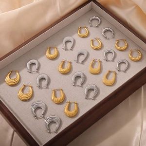 Pendientes de aro en U texturizados en oro y plata con patrones acolchados y estriados