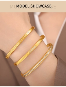 Close-up of three gold-plated titanium steel bracelets with colored crystals on wrist