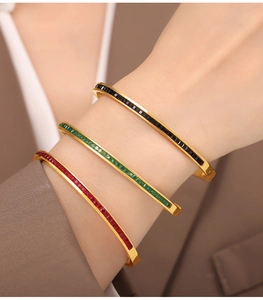 Detail of 18k gold plated bracelets featuring inlaid square colored cubic zirconia stones
