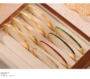 Close-up of 18k gold plated titanium bangles with colorful zircon inlays in a jewelry box