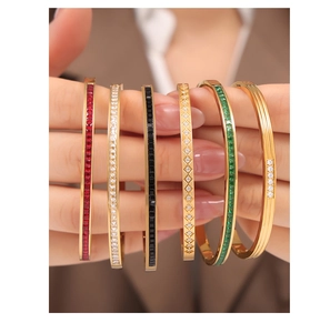 Detail view of gold-plated titanium bracelets with colorful zircons and textured patterns