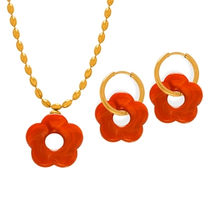 Gold chain jewelry set with orange resin flower pendants for women featuring marbled texture