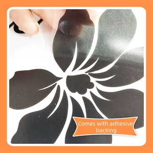 Detail showing self-adhesive wall sticker with transparent backing and black floral pattern