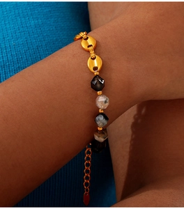 Detail of 18K gold plated bead bracelet with pig nose chain links on a wrist