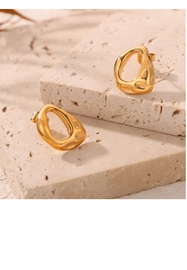 Détail macro de boucles d'oreilles géométriques irrégulières plaquées or 18 carats sur pierre