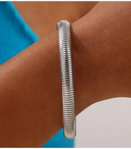 Macro shot of silver flexible spring cuff bracelet with detailed metallic texture