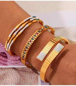 Dettaglio di bracciali vintage in oro e titanio con diamanti e motivi geometrici