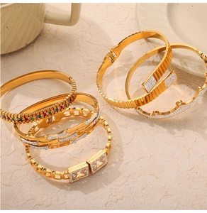 Dettaglio macro di bracciali vintage in titanio placcati oro con motivi a traforo