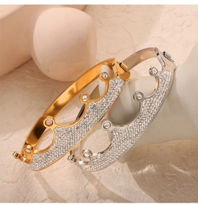 Vista macro di bracciali a corona in oro e argento con dettagli in pavé di diamanti