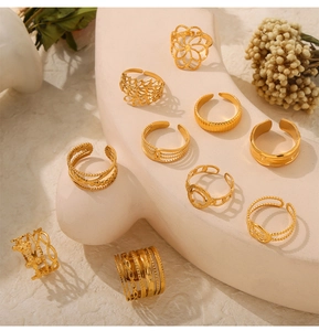 Detailed set of assorted gold-plated titanium steel rings on white pedestal base