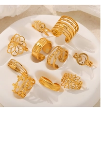 Detailed view of nine piece gold geometric layered open rings on a white tray