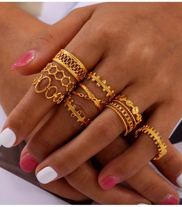 Close-up of gold-plated titanium steel rings featuring hollow weave and geometric designs