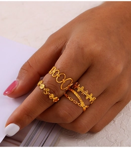 Close-up of four-piece gold-plated titanium steel rings with hollow link designs