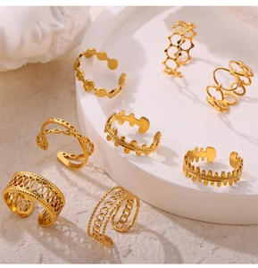 Detail of 8 gold titanium steel rings with geometric hollow and textured designs