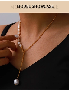Close-up of elegant Y-shaped gold chain necklace with baroque freshwater pearls on a model