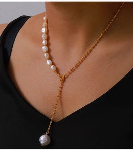Close-up of asymmetric Y-shaped freshwater pearl necklace in titanium steel on skin
