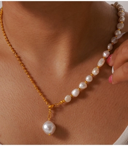 Macro view of French style baroque pearl pendant necklace with gold beaded chain detail
