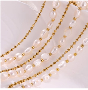 Macro detail of natural freshwater pearls and golden metal beads on a sleek chain