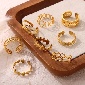 8-piece set of gold plated titanium steel rings with hollow geometric cutouts in a tray