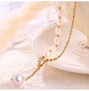 Detail of baroque pearl necklace with gold beads on a vintage white ceramic plate