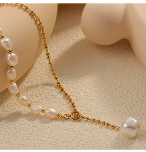 Detailed macro view of baroque freshwater pearl and gold chain with adjustable clasp