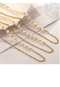 Detail of elegant gold bead chain intertwined with natural irregular freshwater pearls