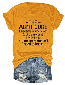 Flat lay of mustard yellow crewneck T-shirt with The Aunt Code print and denim shorts