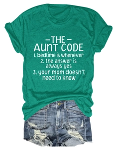 Flat lay of green The Aunt Code printed T-shirt and ripped denim shorts on white background