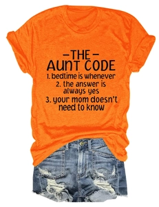 Detailed flat lay of bright orange Aunt Code graphic T-shirt with casual denim shorts