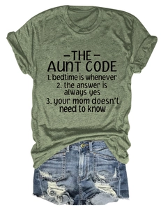 Flat lay of olive green crew neck tee with Aunt Code slogan and ripped denim shorts