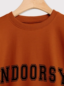 Detail des gerippten Rundhalsausschnitts und Indoorsy-Aufdrucks auf dem orangefarbenen Hoodie