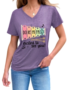 Detail of V-neck purple T-shirt with musical xylophone print and excited text