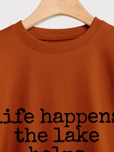 Gros plan sur un sweat-shirt rouge rouille avec l'inscription life happens the lake helps