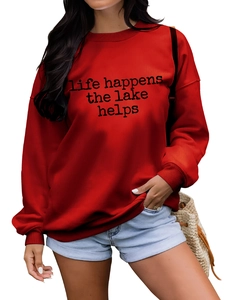 Détail du sweat rouge avec imprimé 'Life Happens The Lake Helps' et finitions côtelées