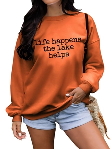 Détail du sweat-shirt orange montrant l'imprimé Life Happens et les poignets côtelés