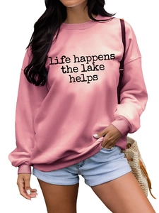 Détail d'un sweat-shirt rose avec imprimé noir 'life happens the lake helps' stylé