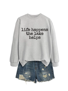 Mise à plat d'un sweat gris à col rond avec imprimé lac et mini short en jean vieilli